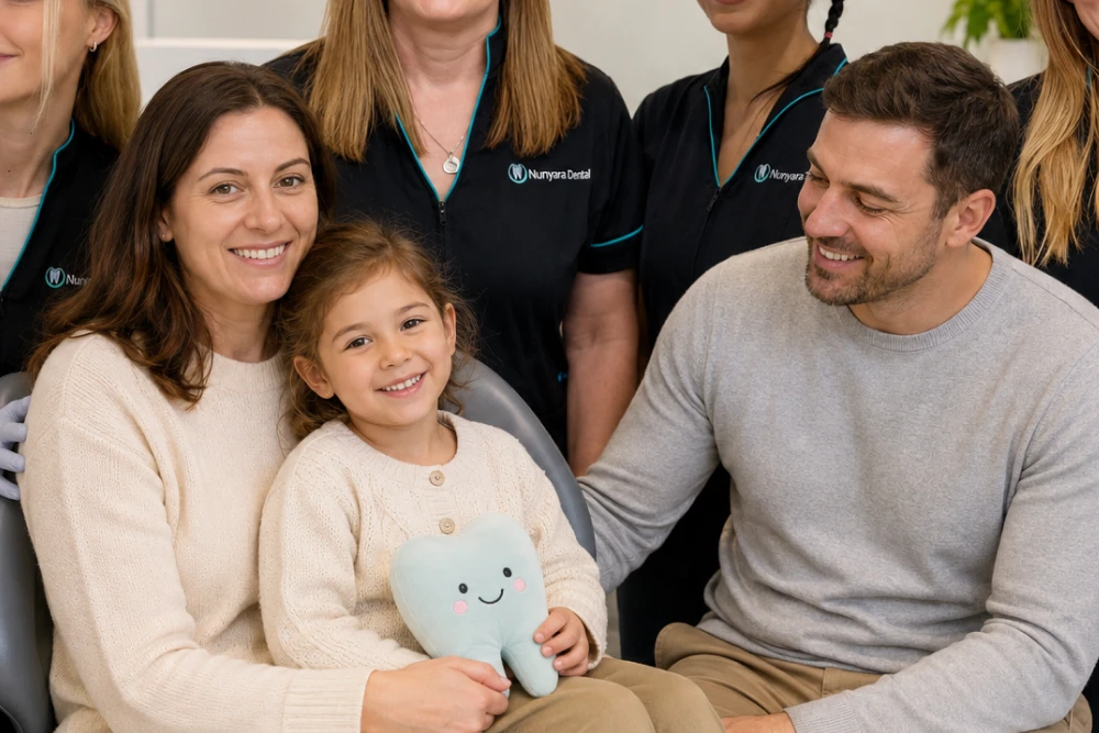 Nunyara Dental practice or team with family and child - Nunyara Dental Mother and daughter sit with the father at a dental clinic; the girl holds a plush tooth while smiling, with staff in Nuryara Dental uniforms in the background.